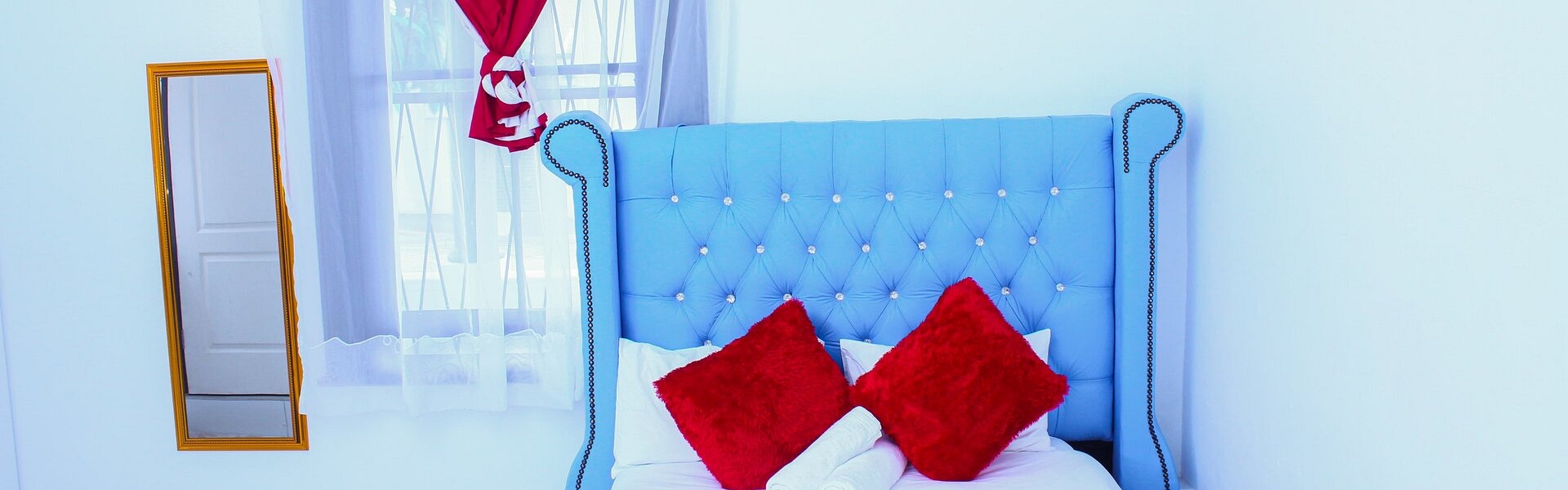 A bed with a vibrant blue headboard A bed with a vibrant blue headboard